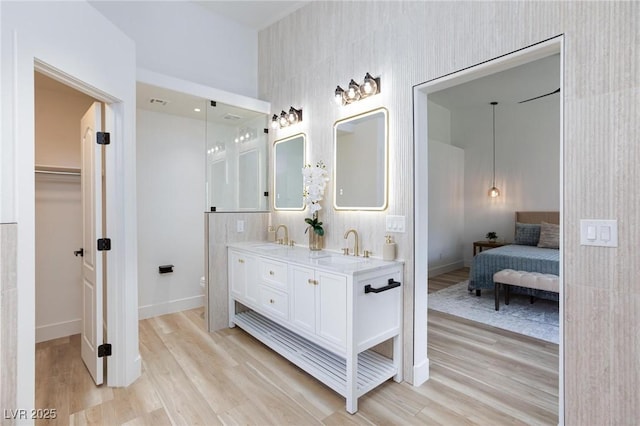 4176 Demoline Cir, Las Vegas, NV 89141 - bathroom with wood finished floors, double vanity, a spacious closet, and connected bathroom