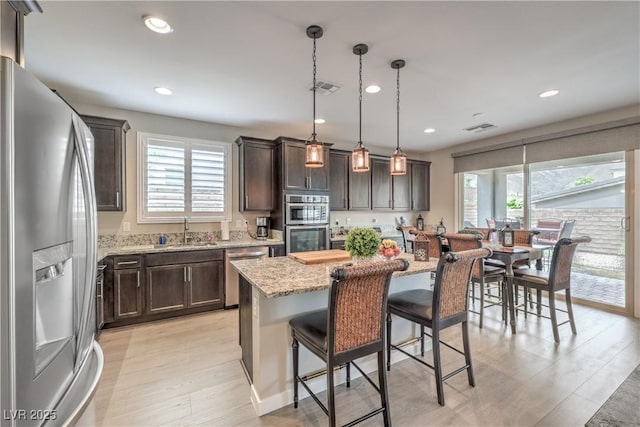 2711 Evolutionary Ln, Las Vegas, NV 89138 - kitchen featuring appliances with stainless steel finishes, a sink, dark brown cabinetry, healthy amount of natural light, and recessed lighting