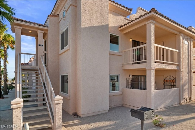 1928 Las Palmas Ln Unit 228, Laughlin, NV 89029 - view of property exterior with stucco siding, stairway, a balcony, and a tiled roof