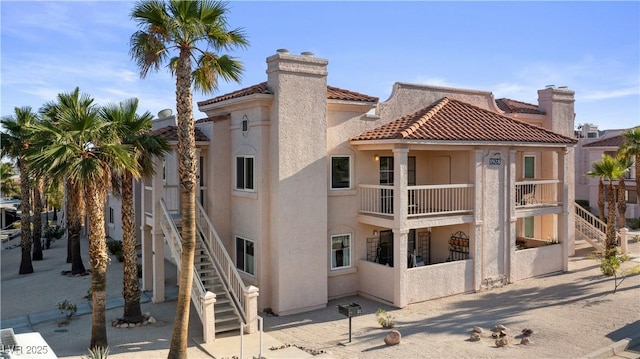 1928 Las Palmas Ln Unit 228, Laughlin, NV 89029 - back of property with stairs, stucco siding, a balcony, a chimney, and a tile roof