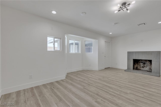 4404 Hillcrest Ave, Las Vegas, NV 89102 - unfurnished living room featuring light wood-type flooring, baseboards, a fireplace with raised hearth, and recessed lighting