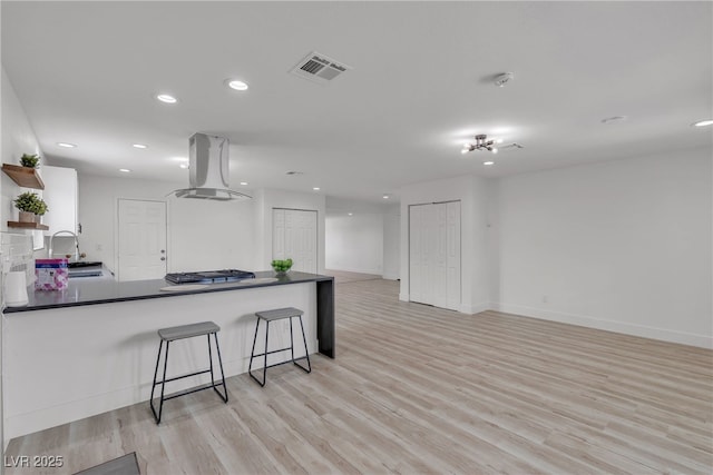 4404 Hillcrest Ave, Las Vegas, NV 89102 - kitchen featuring island range hood, open shelves, dark countertops, recessed lighting, and light wood-type flooring