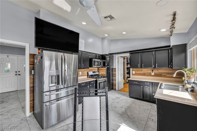 601 Cragin Park Dr, Las Vegas, NV 89107 - kitchen featuring stainless steel appliances, a sink, dark cabinets, tasteful backsplash, and recessed lighting