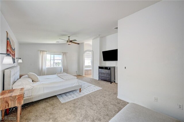 412 Orchid Oasis Ave, North Las Vegas, NV 89031 - carpeted bedroom with arched walkways, a ceiling fan, and ensuite bath