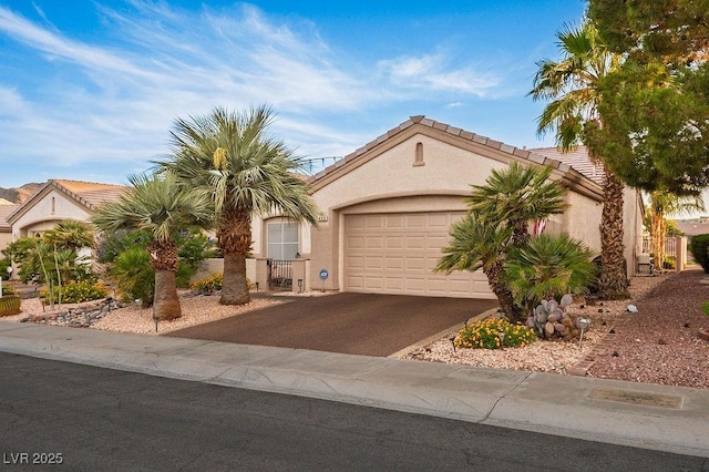 499 Eagle Vista Dr, Henderson, NV 89012 - view of front of home featuring an attached garage, asphalt driveway, stucco siding, and a tile roof