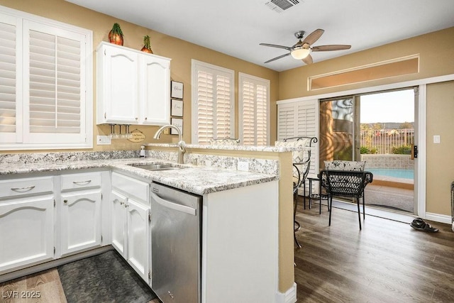 499 Eagle Vista Dr, Henderson, NV 89012 - kitchen with stainless steel dishwasher, a sink, a peninsula, white cabinets, and a ceiling fan