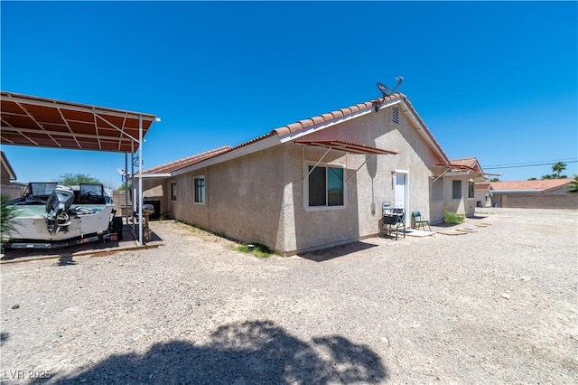 475 E Robindale Rd, Las Vegas, NV 89123 - view of side of property featuring stucco siding, a tile roof, and a carport