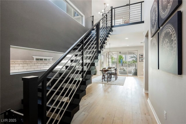 2750 Evolutionary Ln, Las Vegas, NV 89138 - staircase with wood-type flooring, a chandelier, baseboards, and a towering ceiling