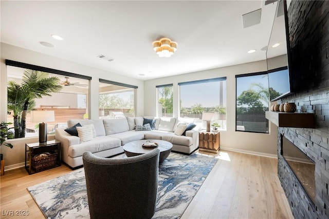 2750 Evolutionary Ln, Las Vegas, NV 89138 - living room with a stone fireplace, light wood-style flooring, baseboards, and recessed lighting