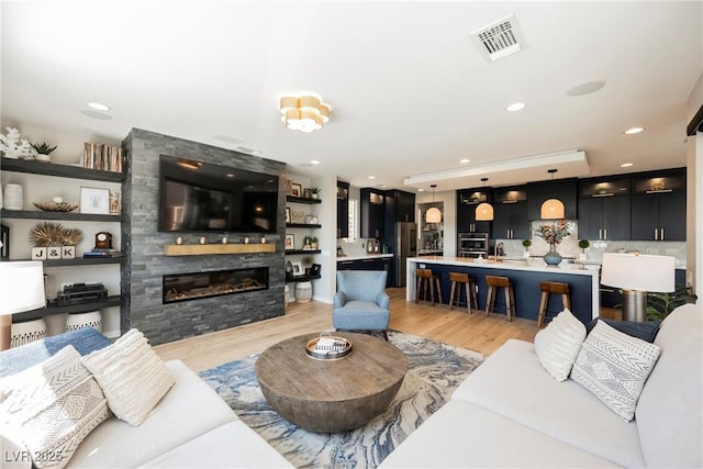 2750 Evolutionary Ln, Las Vegas, NV 89138 - living room featuring light wood-type flooring, a large fireplace, and recessed lighting