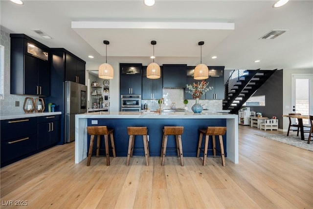 2750 Evolutionary Ln, Las Vegas, NV 89138 - kitchen with appliances with stainless steel finishes, light countertops, decorative backsplash, light wood-style floors, and recessed lighting