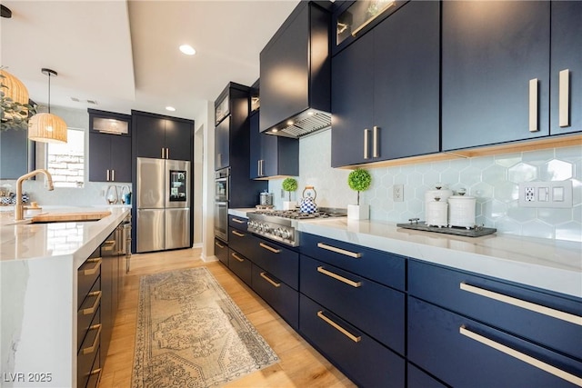 2750 Evolutionary Ln, Las Vegas, NV 89138 - kitchen featuring appliances with stainless steel finishes, a sink, wall chimney exhaust hood, light wood-style flooring, and recessed lighting