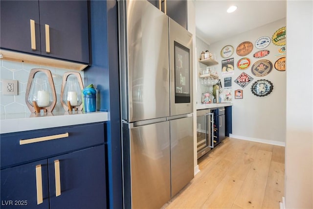 2750 Evolutionary Ln, Las Vegas, NV 89138 - kitchen featuring freestanding refrigerator, blue cabinets, light wood finished floors, light countertops, and recessed lighting