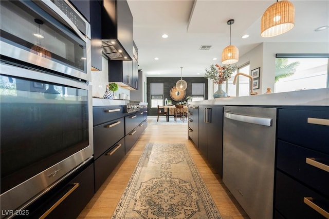 2750 Evolutionary Ln, Las Vegas, NV 89138 - kitchen featuring stainless steel appliances, light wood-type flooring, pendant lighting, modern cabinets, and dark cabinets