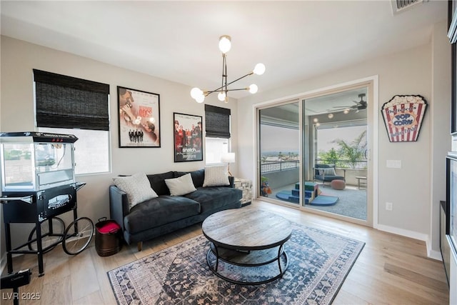 2750 Evolutionary Ln, Las Vegas, NV 89138 - living area featuring healthy amount of natural light, wood finished floors, and a chandelier