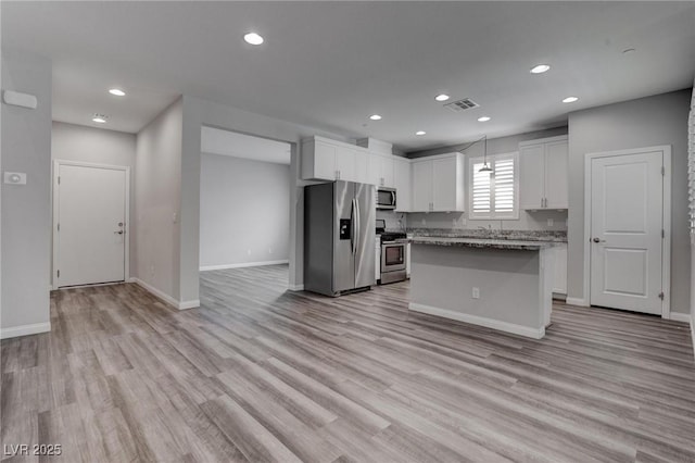 1040 Via Panfilo Ave, Henderson, NV 89011 - kitchen with appliances with stainless steel finishes, white cabinetry, light wood-type flooring, recessed lighting, and a kitchen island