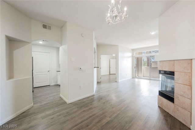 7400 W Flamingo Rd Unit 1082, Las Vegas, NV 89147 - unfurnished living room featuring a tile fireplace, wood finished floors, a chandelier, and recessed lighting