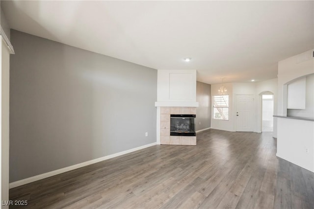 7400 W Flamingo Rd Unit 1082, Las Vegas, NV 89147 - unfurnished living room with wood finished floors, a chandelier, recessed lighting, a fireplace, and arched walkways