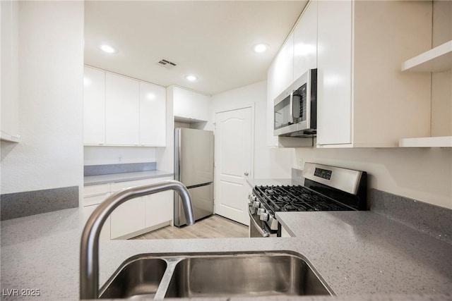 7400 W Flamingo Rd Unit 1082, Las Vegas, NV 89147 - kitchen with stainless steel appliances, white cabinets, recessed lighting, modern cabinets, and light stone countertops