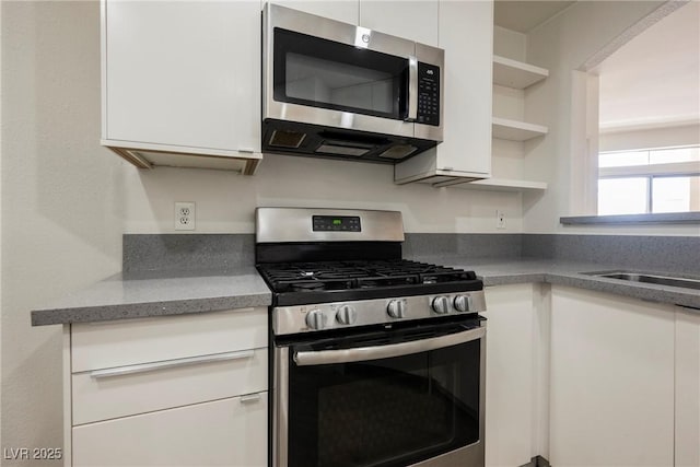 7400 W Flamingo Rd Unit 1082, Las Vegas, NV 89147 - kitchen with stainless steel appliances, open shelves, and white cabinetry