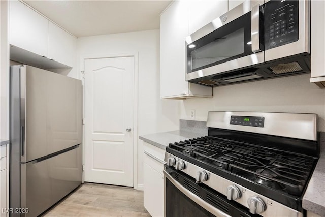 7400 W Flamingo Rd Unit 1082, Las Vegas, NV 89147 - kitchen with appliances with stainless steel finishes, light wood-style floors, white cabinetry, and light countertops