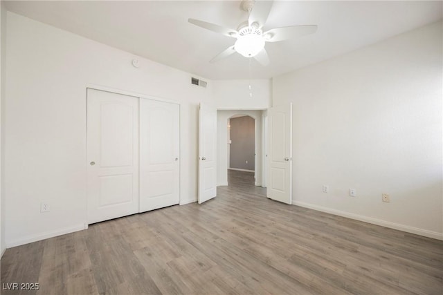 7400 W Flamingo Rd Unit 1082, Las Vegas, NV 89147 - unfurnished bedroom with wood finished floors, arched walkways, a closet, and a ceiling fan
