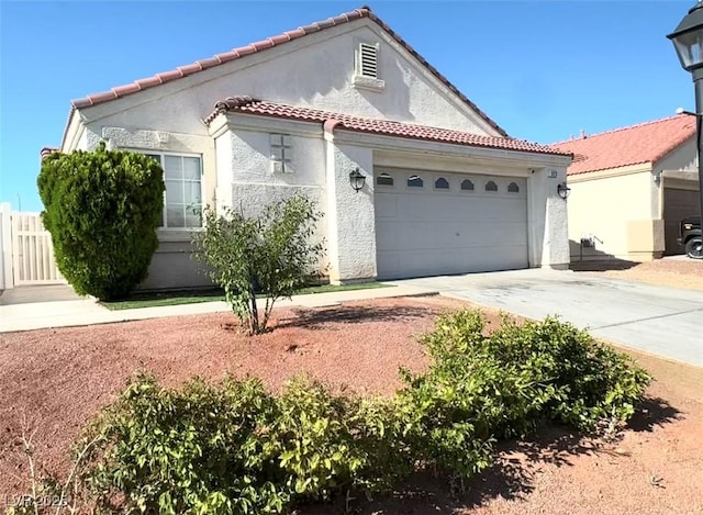 529 Regal Robin Way N, Las Vegas, NV 89084 - mediterranean / spanish house featuring driveway, stucco siding, an attached garage, and a tile roof