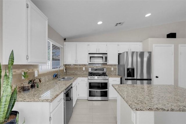 509 Regal Robin Way N, Las Vegas, NV 89084 - kitchen featuring appliances with stainless steel finishes, a sink, lofted ceiling, light stone counters, and white cabinetry