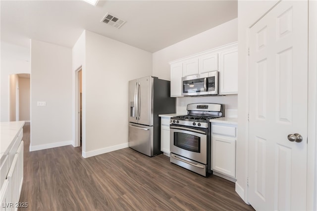 6140 Passionate Ct, North Las Vegas, NV 89031 - kitchen with appliances with stainless steel finishes, dark wood-style floors, white cabinetry, and baseboards
