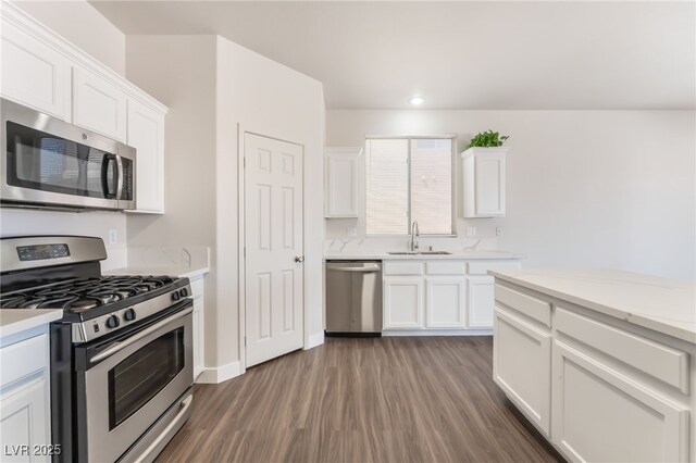 6140 Passionate Ct, North Las Vegas, NV 89031 - kitchen featuring stainless steel appliances, a sink, wood finished floors, and white cabinetry