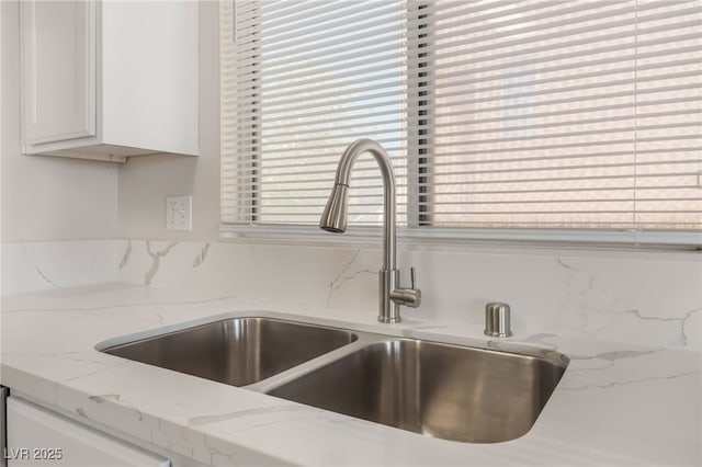 6140 Passionate Ct, North Las Vegas, NV 89031 - kitchen view of a sink, white cabinetry, and light stone counters