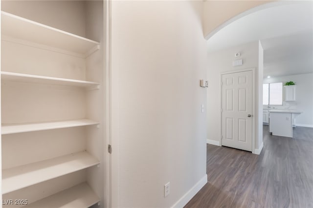6140 Passionate Ct, North Las Vegas, NV 89031 - corridor featuring arched walkways, dark wood-style flooring, and baseboards
