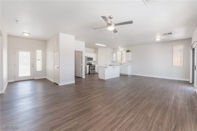 6140 Passionate Ct, North Las Vegas, NV 89031 - unfurnished living room featuring a ceiling fan, baseboards, and dark wood-type flooring