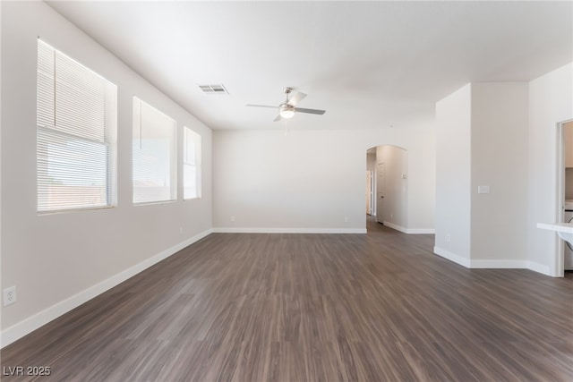 6140 Passionate Ct, North Las Vegas, NV 89031 - spare room featuring ceiling fan, arched walkways, dark wood-type flooring, and baseboards