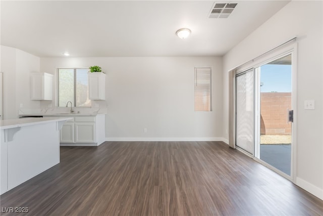 6140 Passionate Ct, North Las Vegas, NV 89031 - kitchen with light countertops, dark wood-style floors, white cabinets, and baseboards