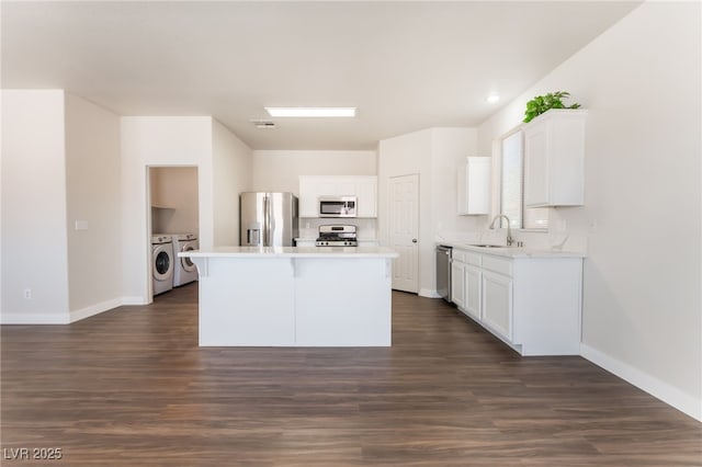 6140 Passionate Ct, North Las Vegas, NV 89031 - kitchen with stainless steel appliances, washing machine and dryer, a sink, and white cabinets