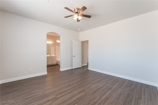 6140 Passionate Ct, North Las Vegas, NV 89031 - unfurnished room with ceiling fan, arched walkways, baseboards, and dark wood finished floors