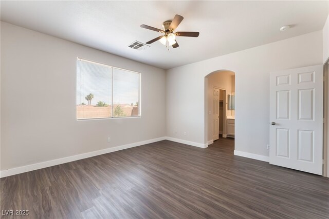 6140 Passionate Ct, North Las Vegas, NV 89031 - unfurnished bedroom featuring arched walkways, dark wood-style flooring, baseboards, and ceiling fan