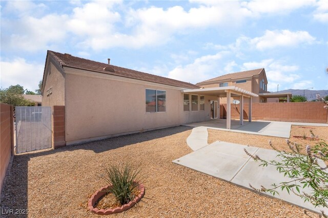 6140 Passionate Ct, North Las Vegas, NV 89031 - back of house with a fenced backyard, a gate, a patio, and stucco siding