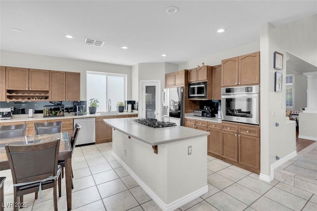 4326 Spooner Lake Cir, Las Vegas, NV 89147 - kitchen with stainless steel appliances, light countertops, a sink, a center island, and light tile patterned flooring