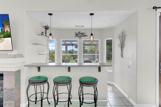 4326 Spooner Lake Cir, Las Vegas, NV 89147 - kitchen featuring a breakfast bar, a peninsula, light tile patterned flooring, and baseboards