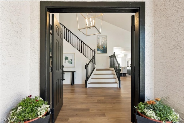 7825 Desert Bell Ave, Las Vegas, NV 89128 - entryway featuring a textured wall, stairway, a chandelier, wood finished floors, and vaulted ceiling