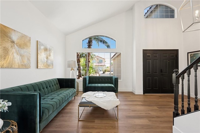 7825 Desert Bell Ave, Las Vegas, NV 89128 - living room featuring high vaulted ceiling, stairs, healthy amount of natural light, wood finished floors, and baseboards