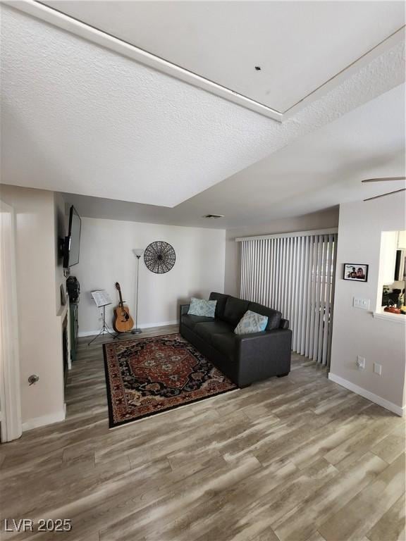 4805 S Torrey Pines Dr Unit 101, Las Vegas, NV 89103 - living area featuring wood finished floors, baseboards, and a textured ceiling
