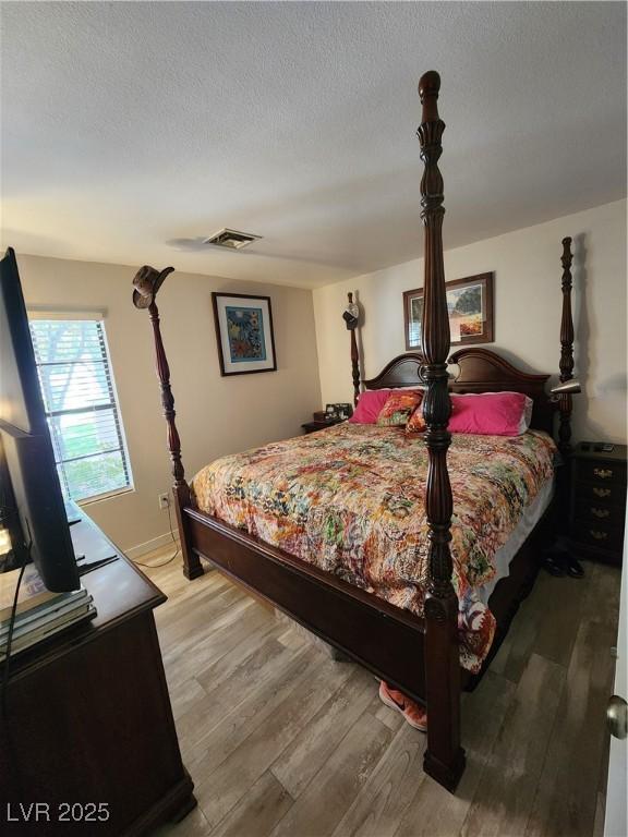4805 S Torrey Pines Dr Unit 101, Las Vegas, NV 89103 - bedroom with light wood finished floors and a textured ceiling