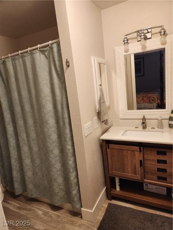 4805 S Torrey Pines Dr Unit 101, Las Vegas, NV 89103 - bathroom featuring vanity, wood finished floors, baseboards, and curtained shower
