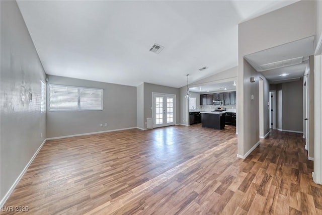 2103 Falcon Crest Ave, North Las Vegas, NV 89031 - unfurnished living room featuring lofted ceiling, wood finished floors, baseboards, and attic access