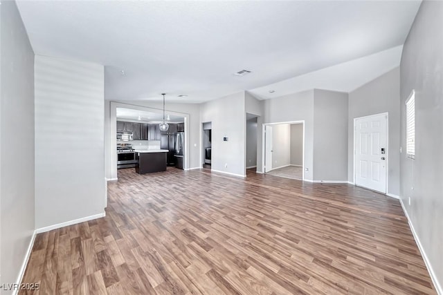2103 Falcon Crest Ave, North Las Vegas, NV 89031 - unfurnished living room with light wood-style floors and baseboards