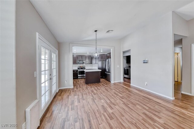 2103 Falcon Crest Ave, North Las Vegas, NV 89031 - kitchen with stainless steel appliances, open floor plan, light countertops, light wood-style flooring, and baseboards