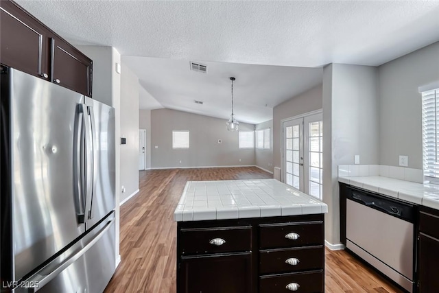 2103 Falcon Crest Ave, North Las Vegas, NV 89031 - kitchen with freestanding refrigerator, dishwasher, light wood-style floors, lofted ceiling, and open floor plan